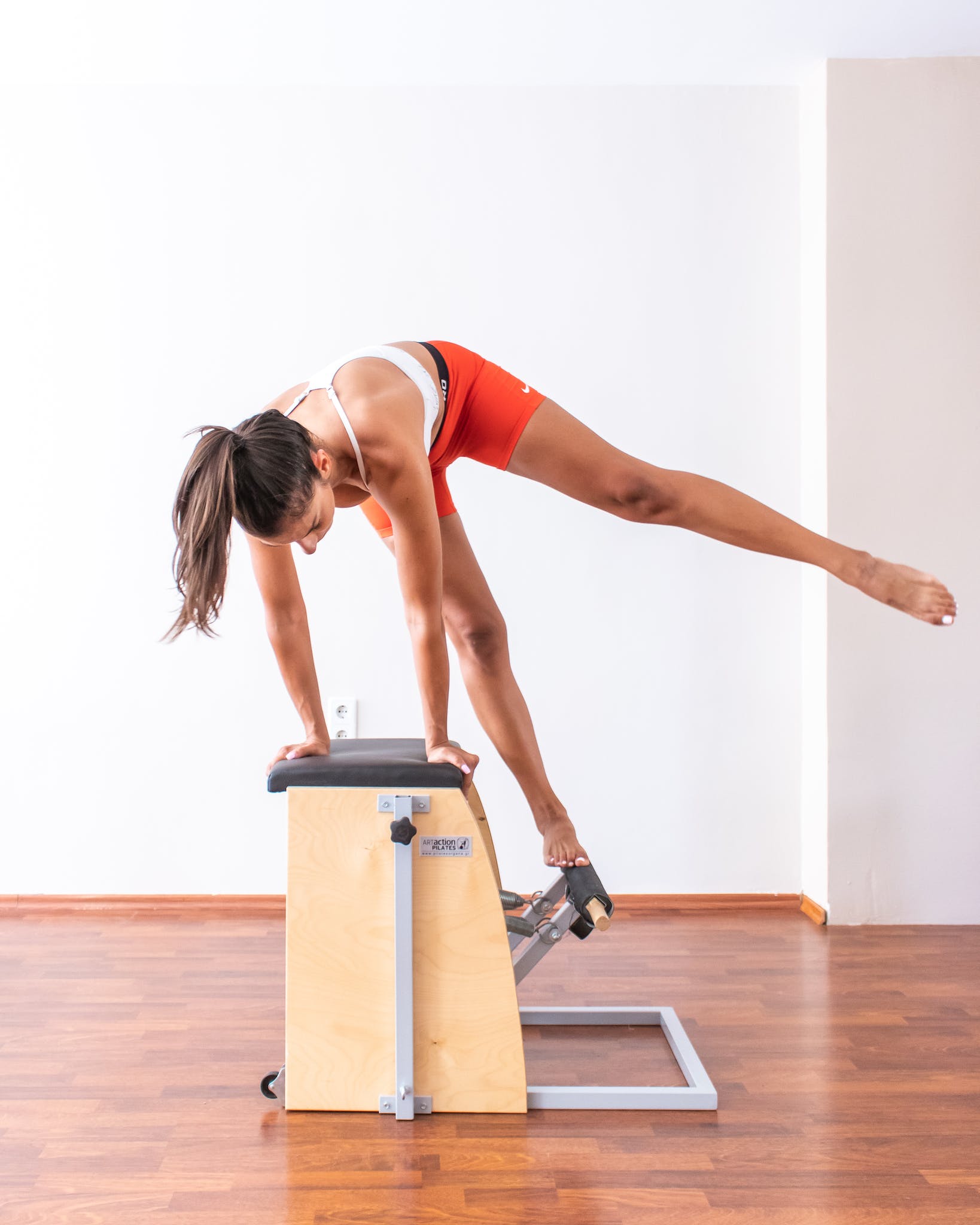 A Woman in Activewear Doing Pilates Reformer Exercise